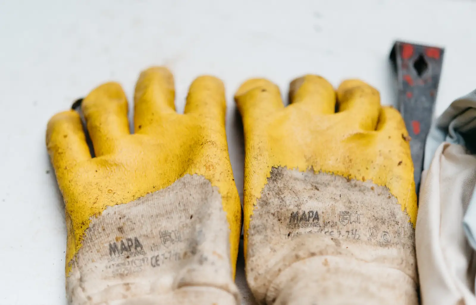 A pair of worn work gloves laid on a bench